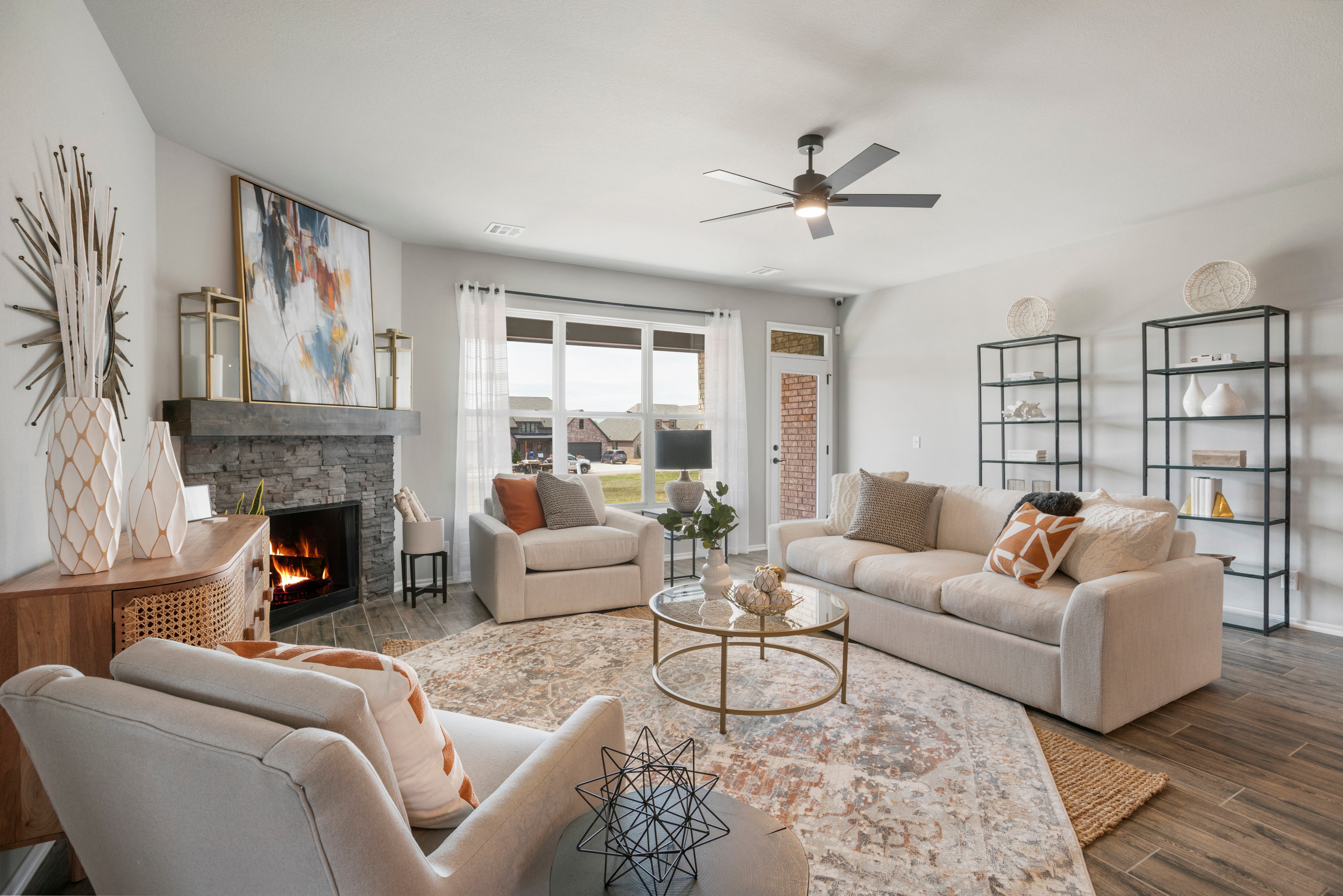 model home living room with fireplace, wood look floors, staged